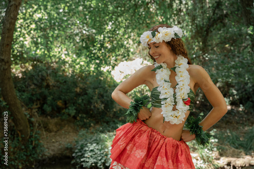 Elegant woman performing Polynesian dance outdoors in the lush rainforest. Concept of Pacific islands art and dance. Sensation of spirituality and connection with nature.