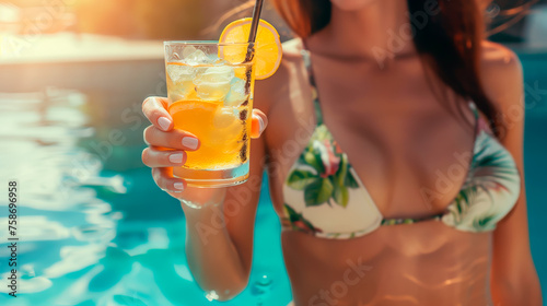 Woman sipping drink poolside, sunny tropical leisure scene, shallow field of view.