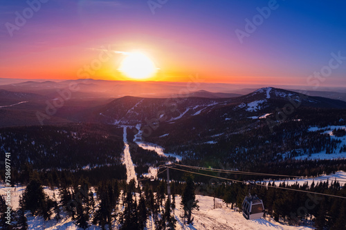 Aerial top view Sheregesh ski lift resort in winter, landscape on mountain with sunset light, Kemerovo region Russia
