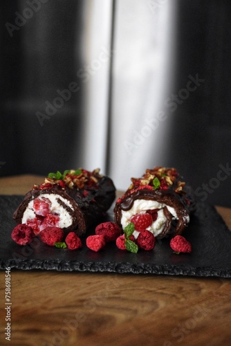 Fototapeta Naklejka Na Ścianę i Meble -  Sweet chocolate roll with whipped cream and raspberries