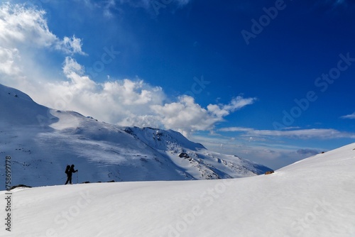 Person ascending a snowy mountain slope