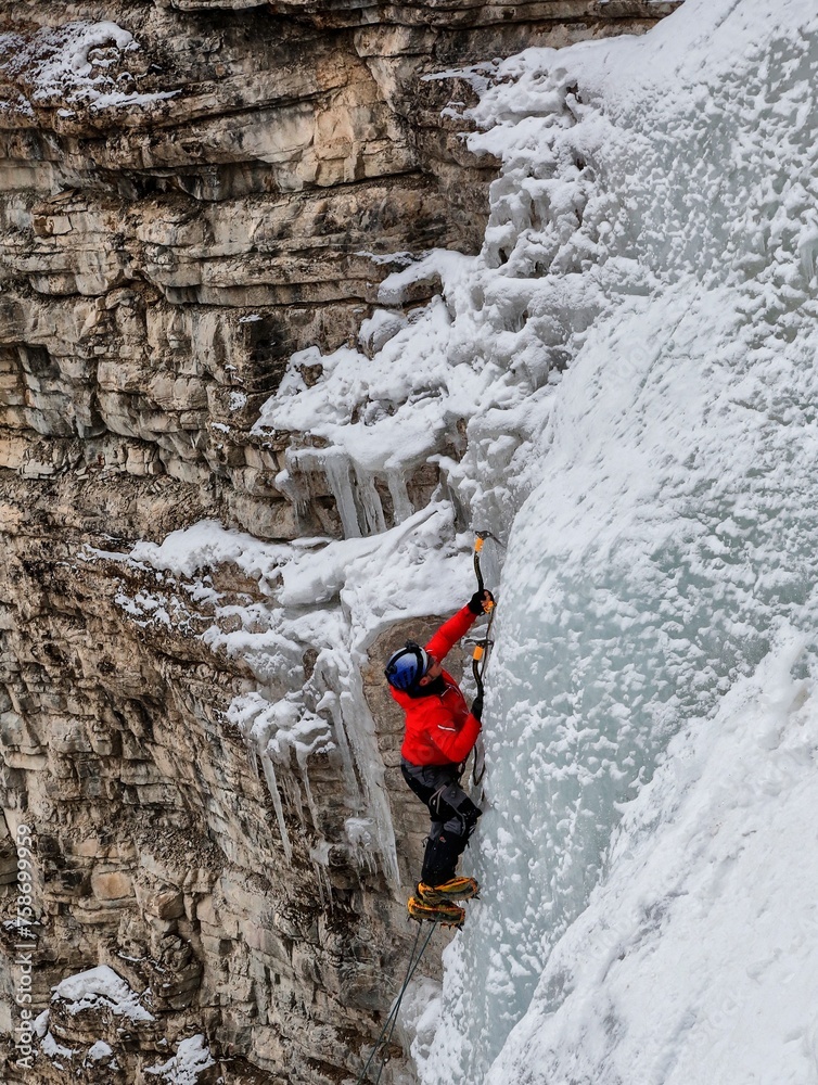 Mountaineer ascending icy peak with specialized gear