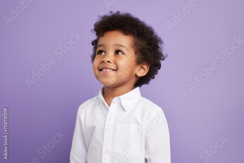 happy african american little boy in white shirt over purple background © Loli