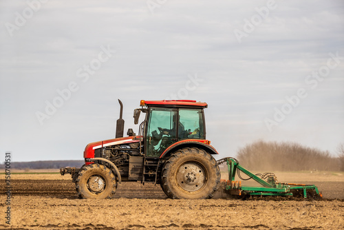 A modern tractor tilling farmland  preparing the soil for planting crops