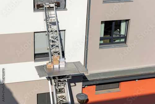 Mover service lifting ladder cargo crane platform vehicle van parked at city street. Retractable furniture elevator machine car pickup truck rental company for relocation and house moving delivery