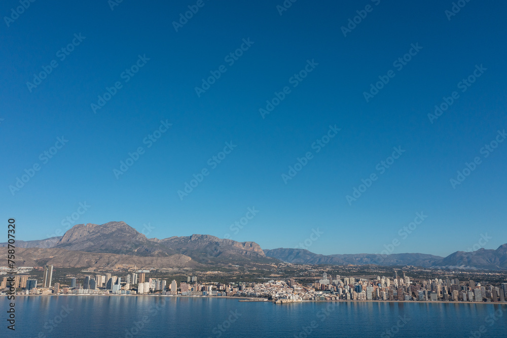 Aerial drone photo of the town of Benidorm in Spain showing the beach front as viewed by the ocean on a clear sunny summers day,