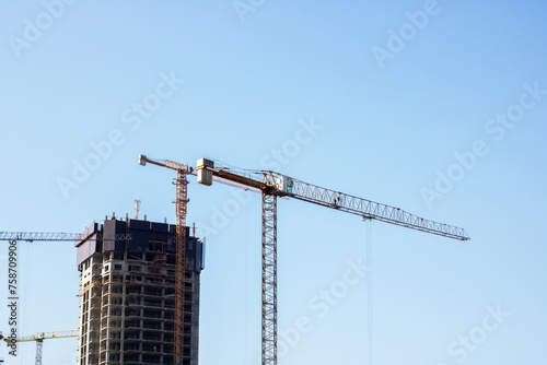 Construction site and crane on bright blue sky background