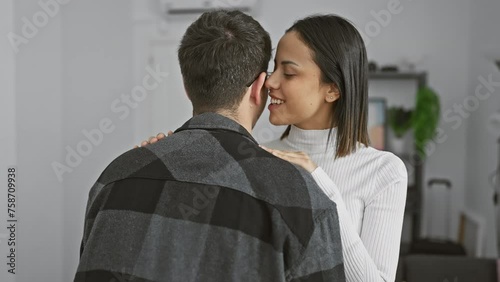 Woman whispering to man in a cozy living room, expressing love and intimacy in a private moment.