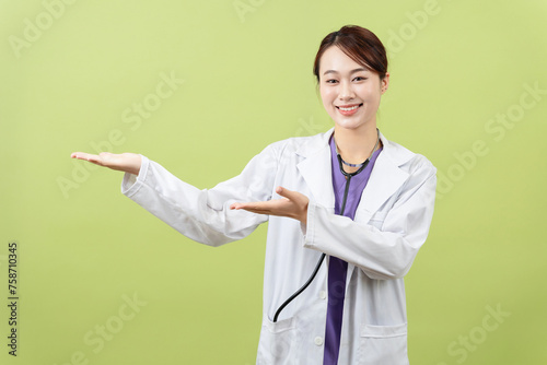 Photo of young Asian femle doctor on green background photo