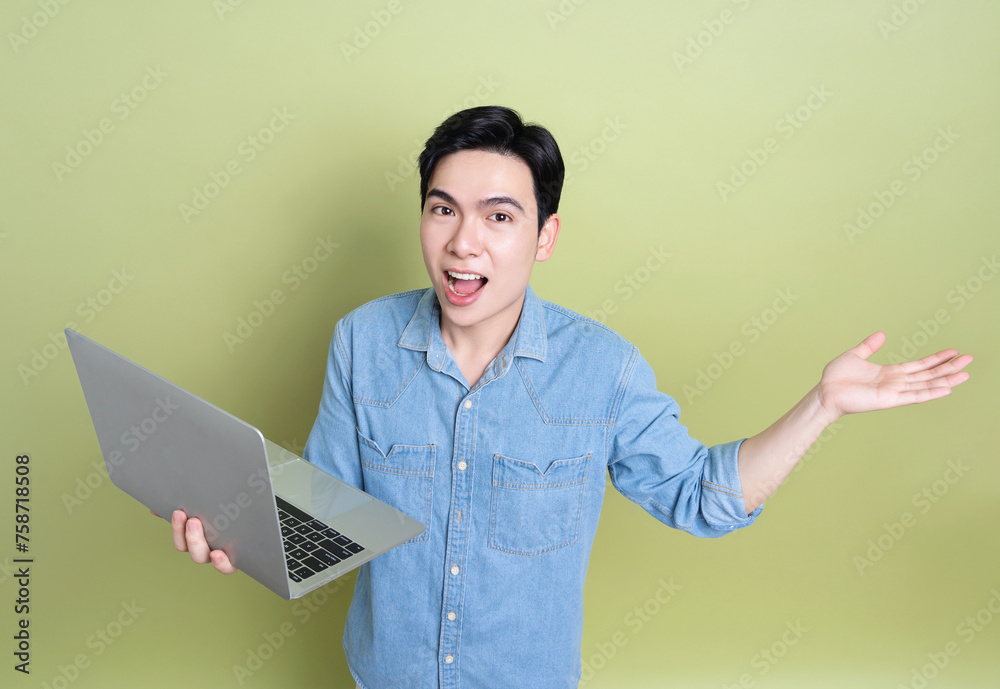 Photo of young Asian man on green background Photo of young Asian man on green background