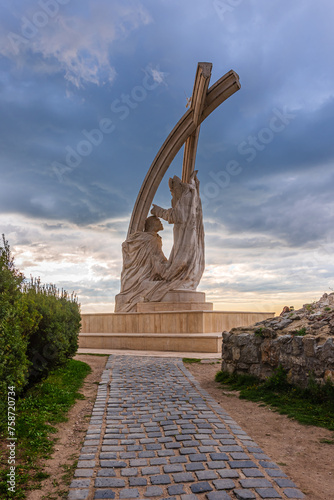 The limestone sculpture in Esztergom depicting King Stephen twice life-size, facing the Danube, being crowned by bishop, Saint Astrik of Pannonhalma. The whole is under two arcs with a cross on top. photo