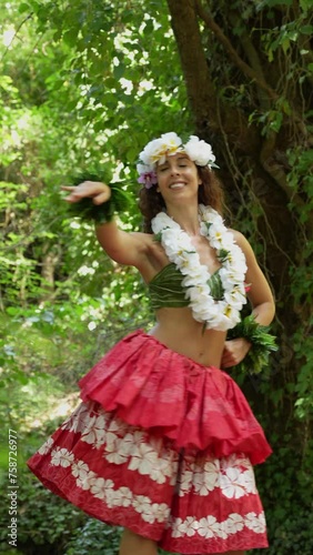 Woman dancing hula in the tropical forest next to the river.