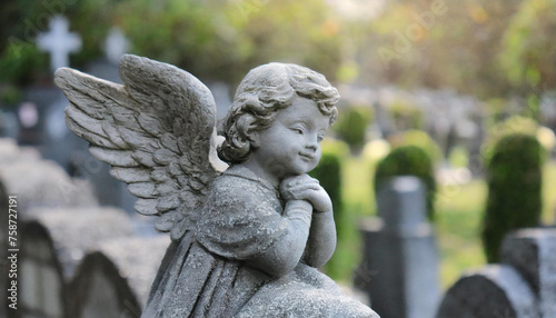 Cherub angel statue in cemetery. Prayerful guardian angel.
