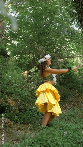 Energetic woman performing traditional Hawaiian dance on the forest vegetation, very happy and joyful.