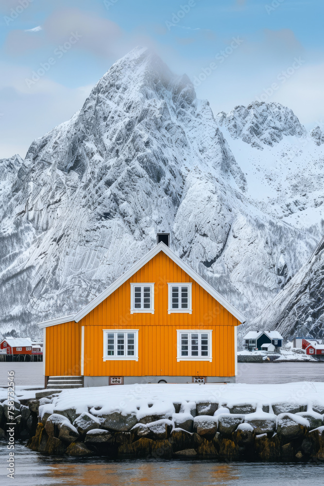Vibrant Orange Cabin Against Snowy Mountain Backdrop in Lofoten