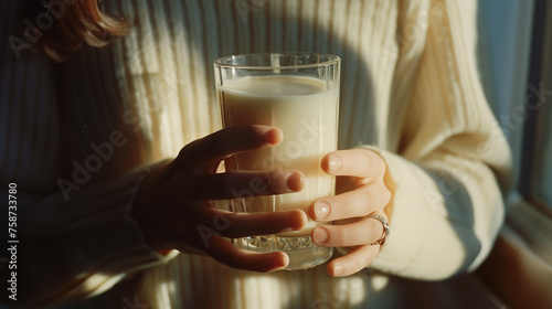 Close up frame of young woman's hands with cup of milk. Almond drink on a light background. classic cow's milk alternative milk, plant, bio eco drinks, vegan