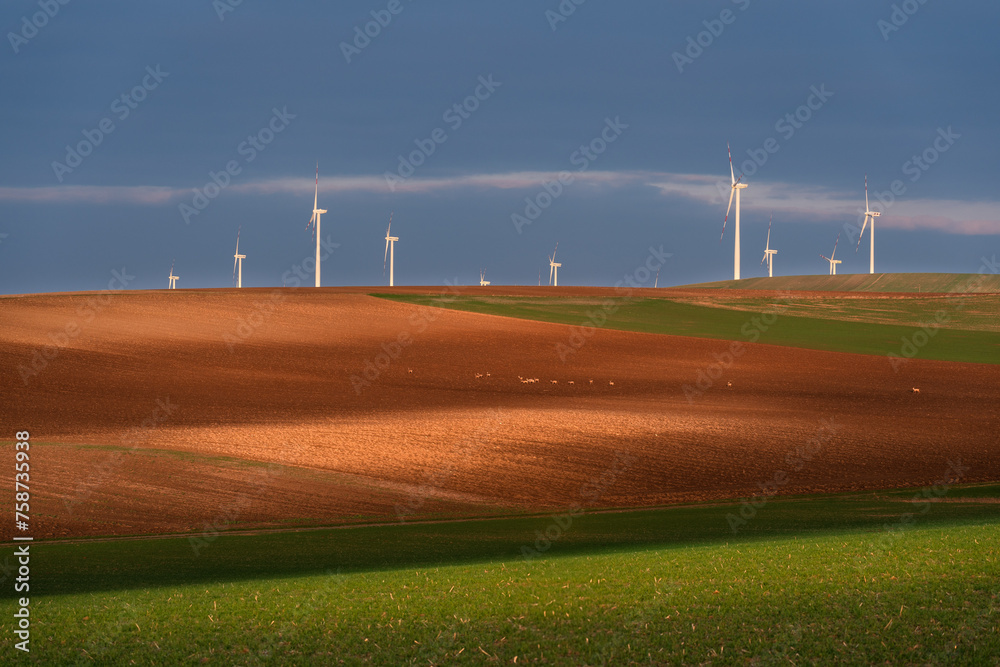 Stunning sunset landscape of Lower Austria adorned with majestic wind turbines. The tranquil beauty of the countryside harmonizes with the modernity of sustainable energy production. Stunning sunset landscape of Lower Austria adorned with majestic wind turbines. The tranquil beauty of the countryside harmonizes with the modernity of sustainable energy production.