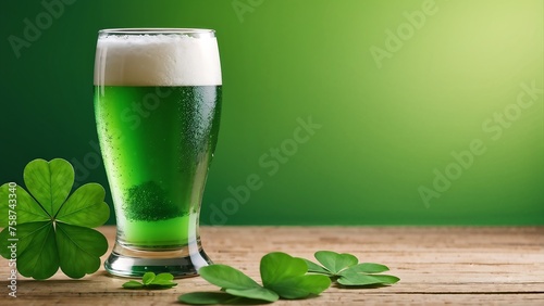 Green beer in a glass on a wooden surface with blurred green backdrop and clover leaves.