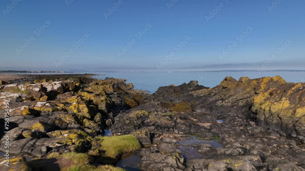 Aerial view of Longniddry Bents beach with clear blue water and rocky coastline, East Lothian, Scotland, United Kingdom. Aerial view of Longniddry Bents beach with clear blue water and rocky coastline, East Lothian, Scotland, United Kingdom.