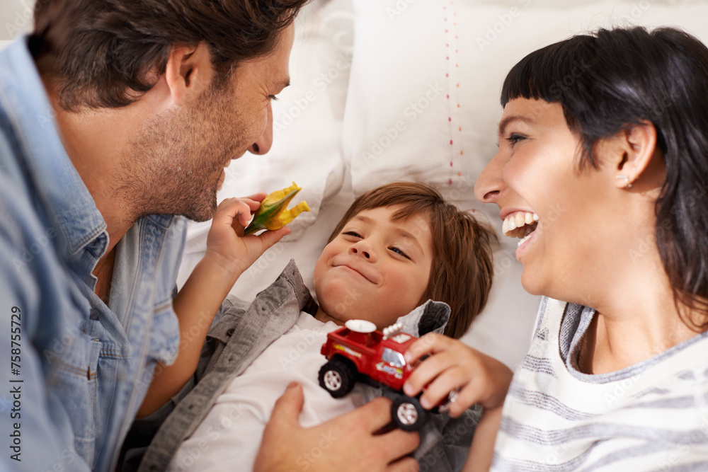 Family, toys and kid playing in bedroom together for bonding, having fun and entertainment in home. Childhood development, Australian man and woman with child for joke, laughing and relax on bed
