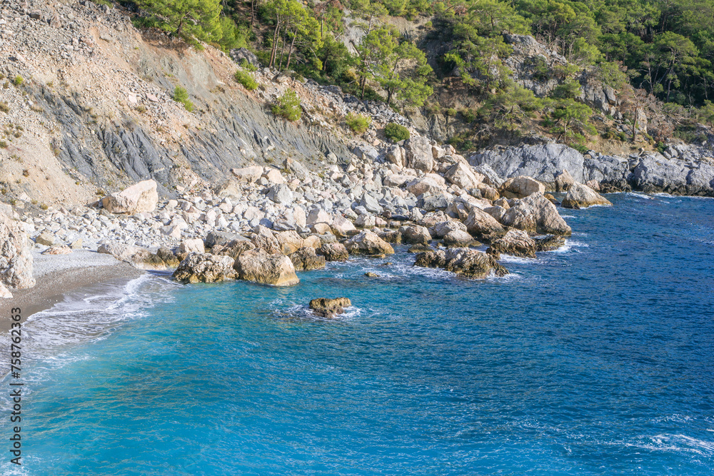 Beautiful small rocky beach with clear blue sea. Oludeniz, Turkey.
