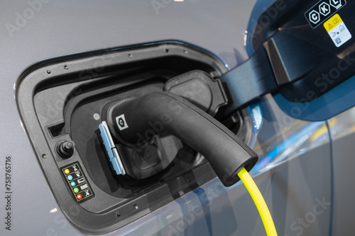 Power cable connected with a charger plugged into electric car