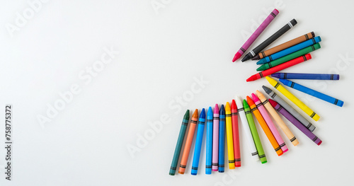 Colored wax crayons for drawing on a white blank sheet of paper