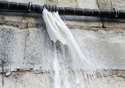 Frozen water after burst from a pipe at the winter.