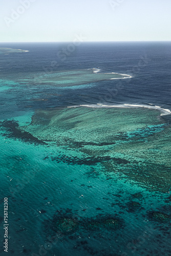 Scenic flight over the Ningaloo reef in Exmouth, Australia. Beautiful aerial view of coral reef, ocean, waves and crystal blue water.  Breathtaking point of view.