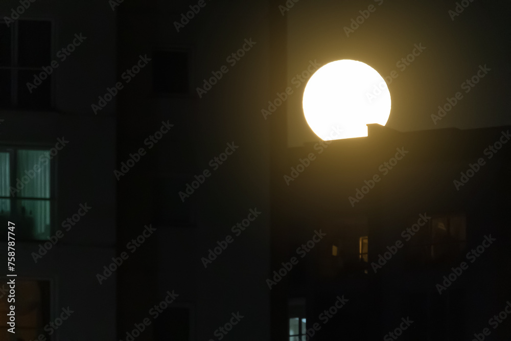 Fototapeta premium Night view of the city. Black sky and moon, light and cityscape.