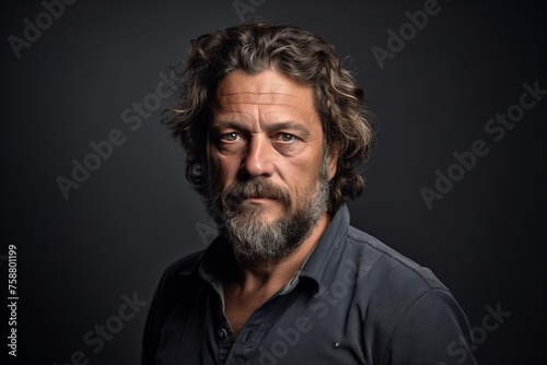 Handsome middle aged man with long grey hair and beard in a studio portrait