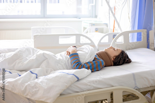 Preteen child, boy, lying in hospital with fractured thoracic spine, vertebralis photo