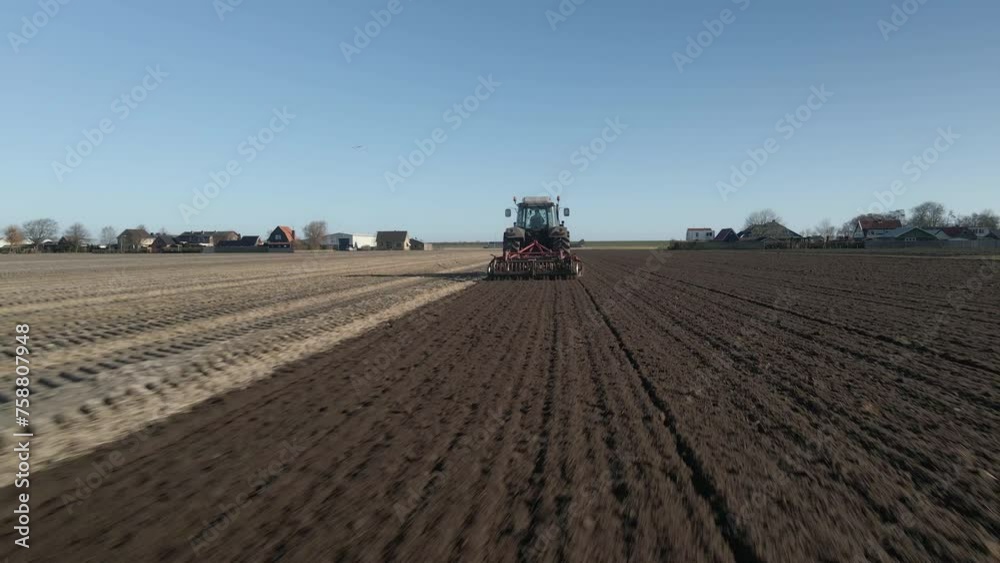 Alkmaar, Netherlands - 25 April 2023: Aerial view of tractor plowing field for sowing new crops in spring, Netherlands Alkmaar, Netherlands - 25 April 2023: Aerial view of tractor plowing field for sowing new crops in spring, Netherlands
