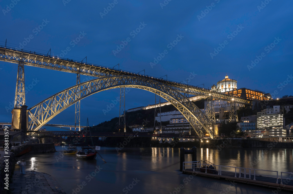 Night view of Porto with Dom Luis I Bridge, Duoro river and Mosteiro da Serra do Pilar with reflection in water