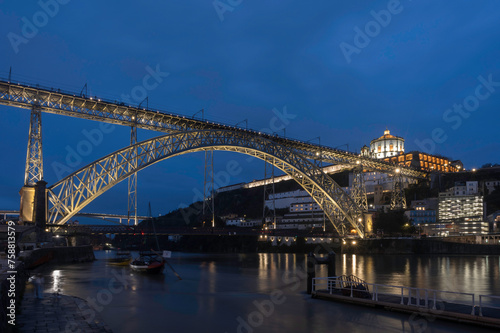 Night view of Porto with Dom Luis I Bridge, Duoro river and Mosteiro da Serra do Pilar with reflection in water © parkerspics