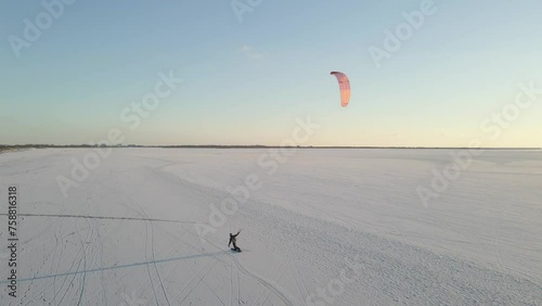 Aerial view of people snowkiting sport on frozen ice lake in winter, Netherlands