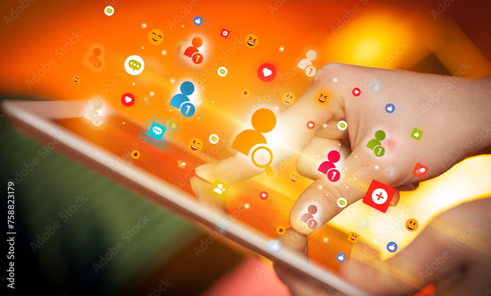 Close-up of a hand using tablet with social media icons