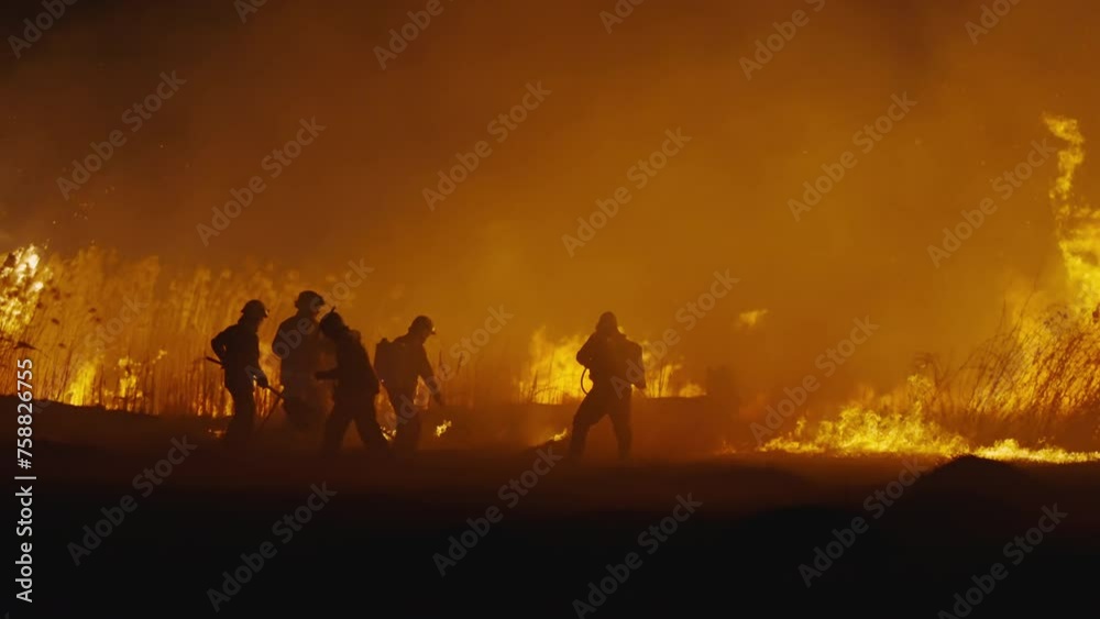 Firefighters estinguishing forest bushfire fire at night