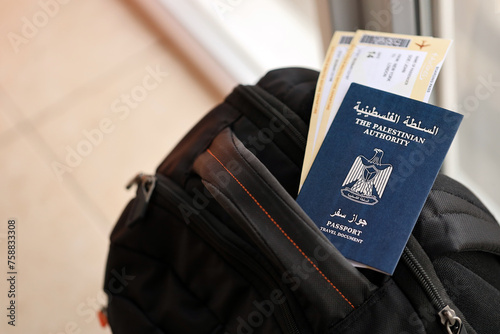 Blue Palestinian Authority passport with airline tickets on touristic backpack close up. Tourism and travel concept