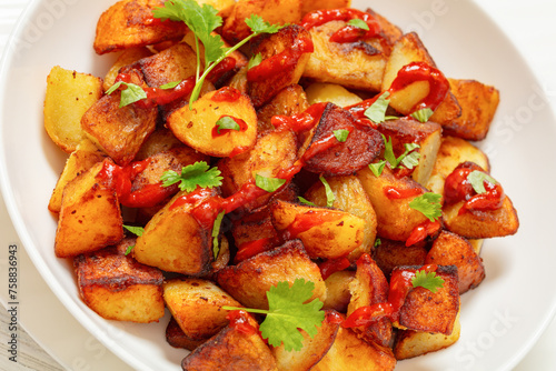 fried spanish potatoes with paprika sauce in bowl © myviewpoint