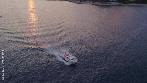 Aerial view of small boat cruising on Adriatic Sea during sunset, Dubrovnik, Croatia