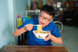 Korean,Japanese,Asian man eating Instant noodles very hot and spicy in local restaurant location.Food concept.