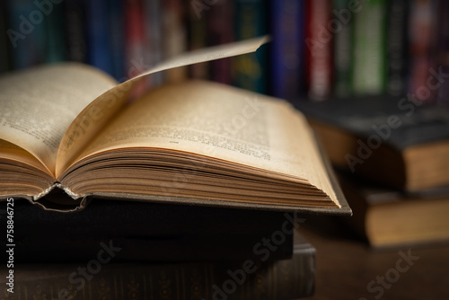 opened book, lying on the bookshelf in library © eliosdnepr