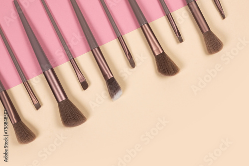 Cosmetics and beauty. Make-up brushes set in row on pink background