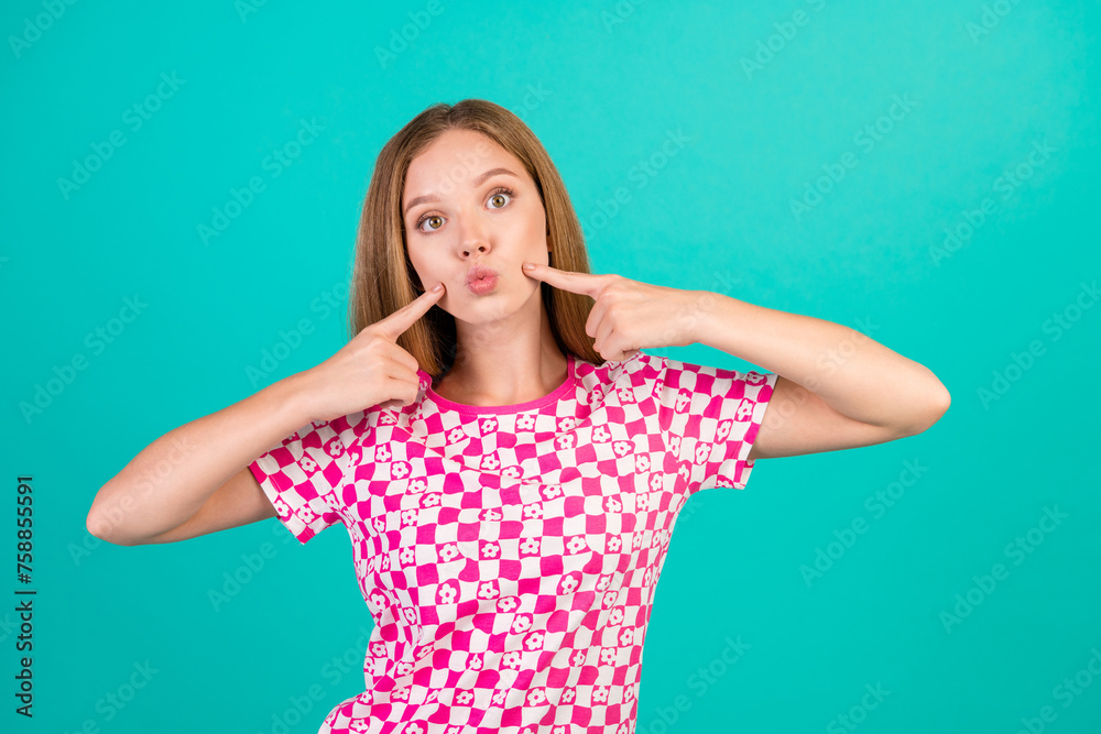 Photo portrait of pretty teenager girl fingers point cheeks plump lips wear trendy print pink clothes isolated on cyan color background - obrazy, fototapety, plakaty 