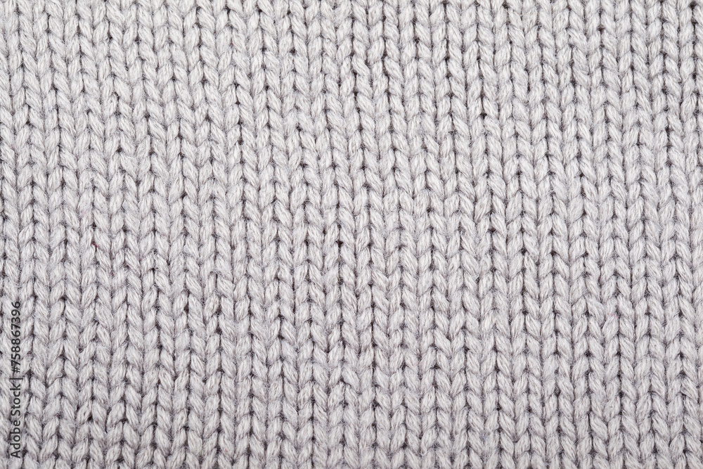 The texture of a knitted woolen fabric gray. Background The texture of a knitted woolen fabric gray. Background