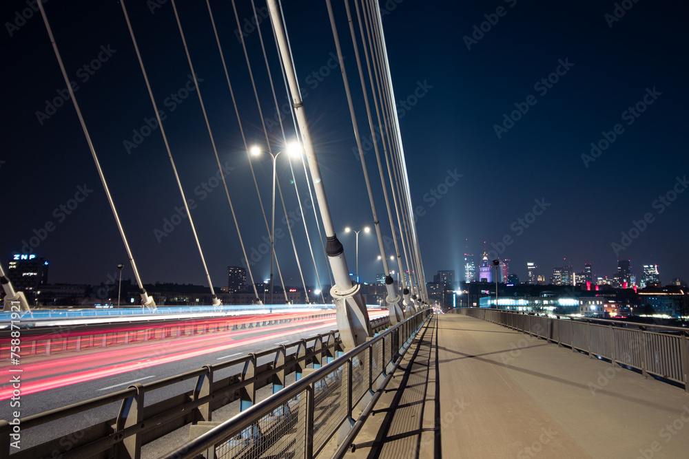 Naklejka premium Light trails on a road and a city skyline 