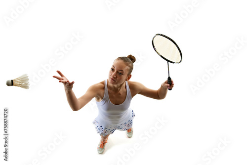 Top view dynamic image of young girl in uniform playing badminton, training isolated over white background. Concept of professional sport, active lifestyle, hobby, game, competition