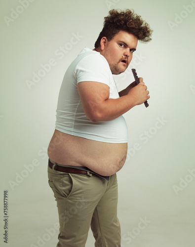 Billede på lærred Chocolate, portrait and plus size man with eating food, dessert and candy in a studio
