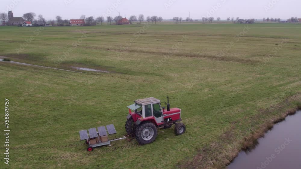 Aerial view of tractor with solar powered water pump ready for instal in grassland, Friesland, Netherlands Aerial view of tractor with solar powered water pump ready for instal in grassland, Friesland, Netherlands